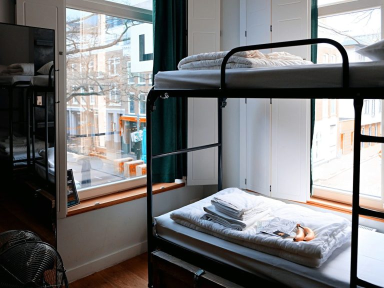 Blick auf ein Zimmer mit Hochbetten und frischen Handtüchern neben einem Fenster.