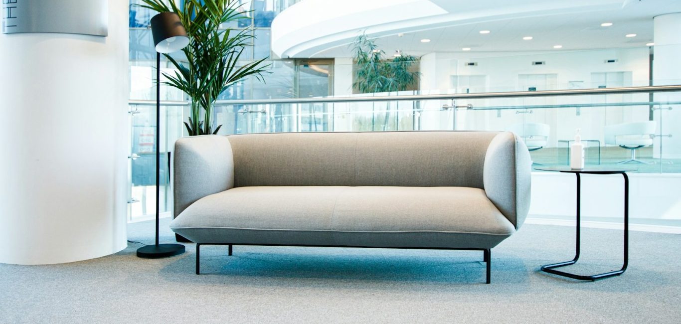 Langer, heller Flur mit Fenstern und Pflanzen entlang der Wände.