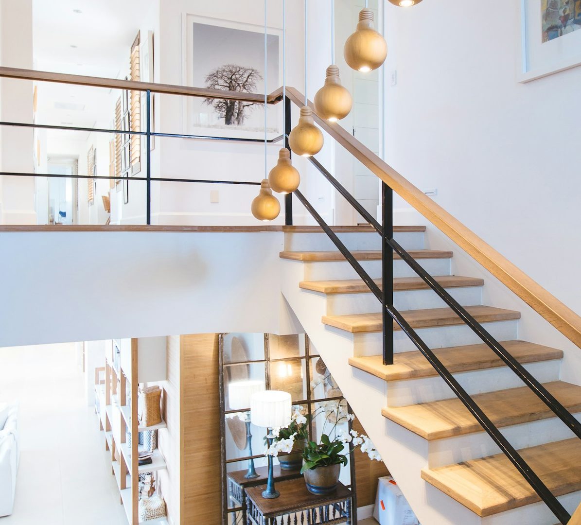 Holztreppe mit modernen Geländern und einigen hängenden Dekorationen.